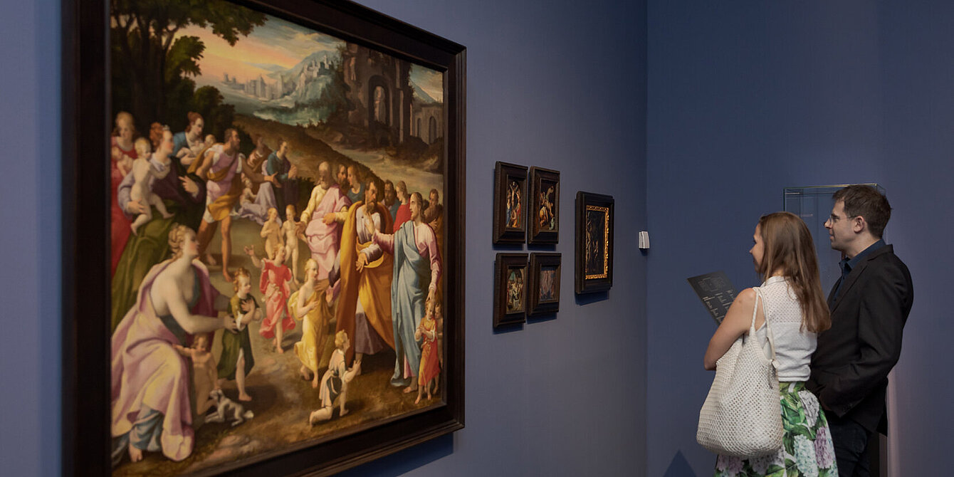 Museumsbesucher*innen stehen vor einem großformatigen, barocken Gemälde in der Alten Galerie, das eine Gruppe an biblischen Personen zeigt.