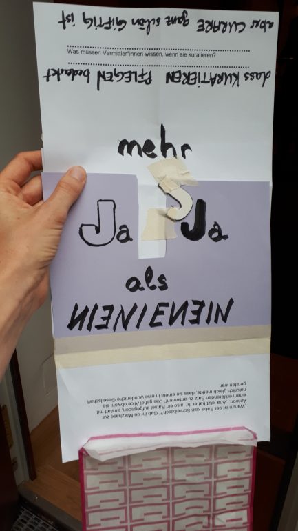 Ein Produkt der interaktiven Workshopsequenz zu Utopien der Co-Produktion von Kurator*innen und Vermittler*innen, Hand hält Plakat mit der Aufschrift "Mehr Ja Ja als Nein Nein"
