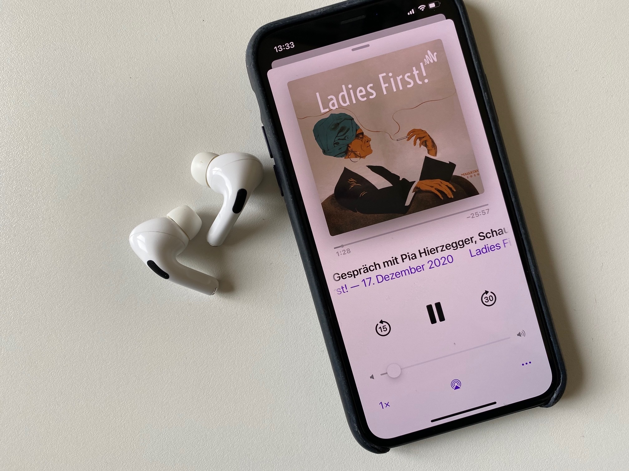 Ein I-Pod zeigt den Podcast Ladies First zur gleichnamigen Ausstellung in der Neuen Galerie Graz, daneben liegen Kopfhörer