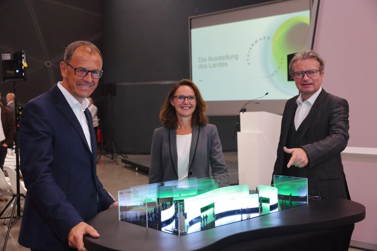 Kulturlandesrat Christopher Drexler und die Direktor*innen des Universalmuseums Joanneum Wolfgang Muchitsch und Alexia Getzinger betrachten das Modell des mobilen Pavillons der STEIERMARK SCHAU, die die Landesausstellung neu interpretiert.