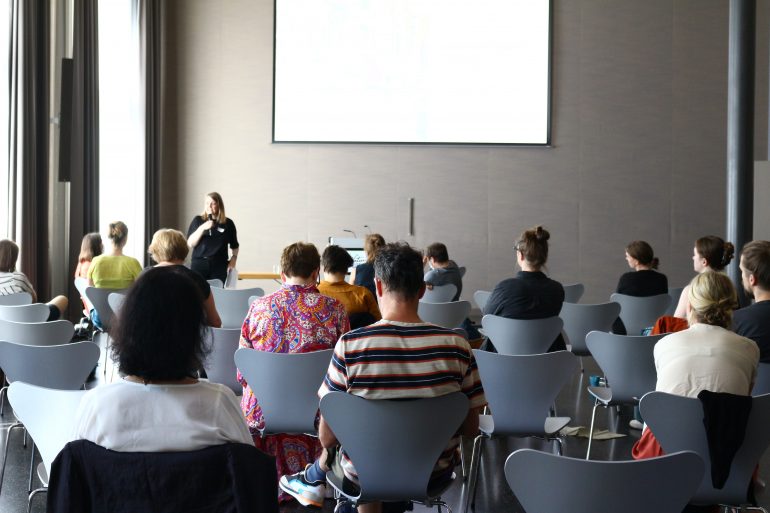 Vortrag bei einer Museumsakademie-Veranstaltung Berlin Aktivismus und Museen, Zuseher*innen von hinten, weiße Leinwand