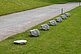 Six concrete stones in a row, modeled on the original limestone. Next to it, at the same distance, a 0.4-fold version of one of the stones.