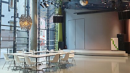 In Space04 there is a meeting table with armchairs under a silver ceiling light. In the background is the podium.