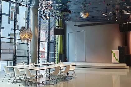 In Space04 there is a meeting table with armchairs under a silver ceiling light. In the background is the podium.