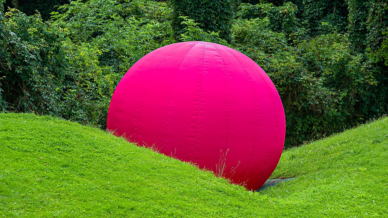 Mitten im Skulpturenpark, hinter dem Berggartencafé. Ein großer sich aufblasender Ball, der mit einem Knall implodiert und in sich Zusammenfällt, zählt zu den Lieblingswerken unserer jüngsten Besucher*innen. 