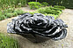 Die Skulptur aus Aluminium stellt ein überdimensionales Rosenblatt dar. 
Die Skulpturen sind in vier unterschiedlichen Farben an öffentlichen Orten, in Parks und Gärten platziert. Die hier im Bauerngarten befindliche schwarze Rose entfaltet ihre Wirkung im Wechselspiel mit der sie umgebenden Natur.