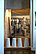 Photography of an exhibition room. On the floor are four white cylindrical blocks of salt. Behind them is a large-scale photograph of men making these blocks of salt.