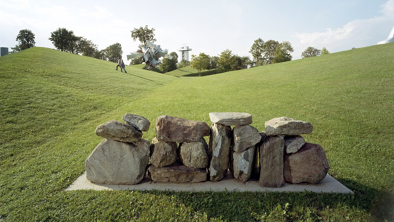 Concrete base with medium-sized stone blocks arranged to form a "wall". You can walk past the "wall" on the sides.