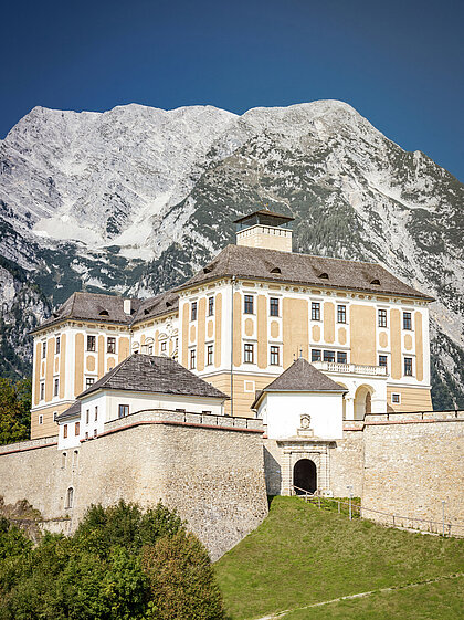 Schloss Trautenfels bei blauem Himmel im Hintergrund ist der Berg Grimming