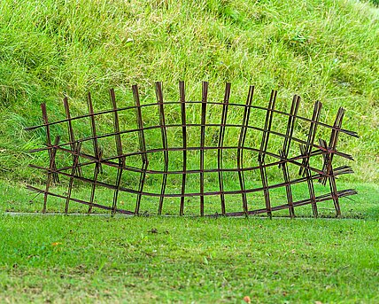 Oxidized structural steel lattice whose struts are interwoven like branches or wood to form a regular "grid".