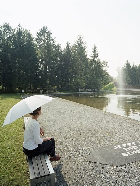 If you take a seat on the bench selected as the trigger, a water fountain develops in the middle of the water lily pond, towering above the treetops. The viewer thus becomes an essential part of the sculpture, which is necessary to make the work of art visible in the first place and, with a time delay, also audible.