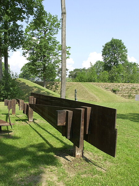 The steel sculpture, which weighs several tons, is ten meters long, two and a half meters wide and one and a half meters high. The work can be read as a relic of an archaic culture as well as a find from the archaeology of the industrial age.