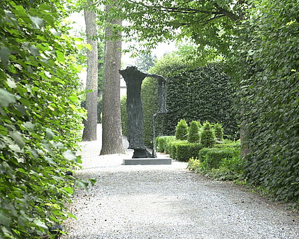 Bronze sculpture on a concrete base that impressively reproduces a solidified waterfall. 