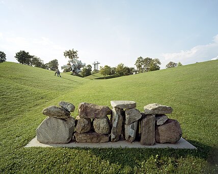 Concrete base with medium-sized stone blocks arranged to form a "wall". You can walk past the "wall" on the sides.