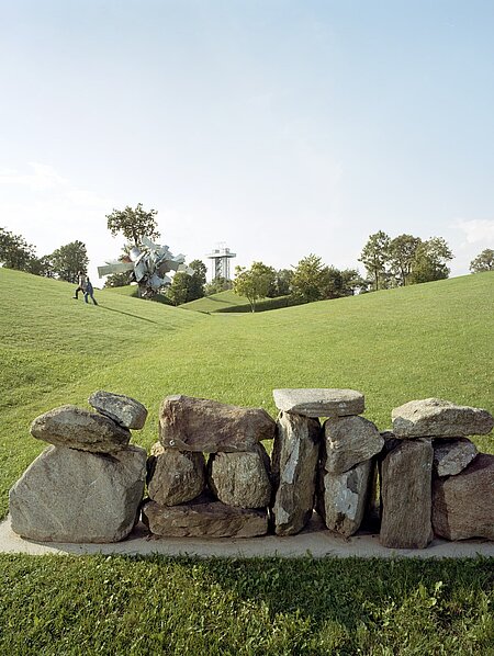 Concrete base with medium-sized stone blocks arranged to form a "wall". You can walk past the "wall" on the sides.