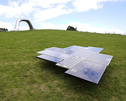 A sculpture made of photovoltaic peneels of various ages. 