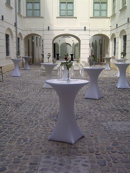 Standing tables are distributed in the inner courtyard of the History Museum.