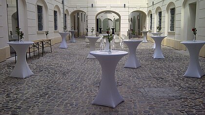 Standing tables are distributed in the inner courtyard of the History Museum.