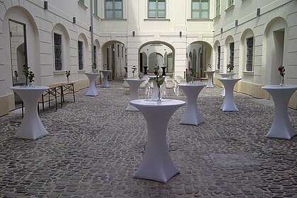Standing tables are distributed in the inner courtyard of the History Museum.