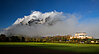 The mountain Grimming is surrounded by fog, in front of it you can see the castle Trautenfels, which is shined by the sun.