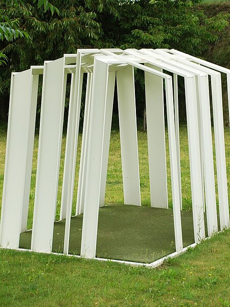 Erjautz baut seine Skulptur als Gebäude bzw. Zelt. aus weißen, Metall gewordenen Linien, abgeleitet von Computerstrichcodes. 