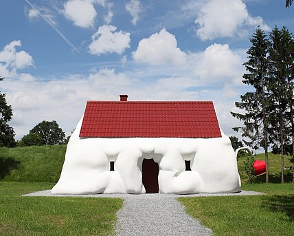A swollen detached house that thematizes wealth and consumption. 