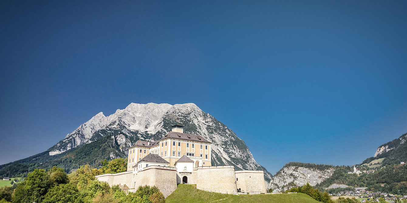 Trautenfels Castle with a blue sky in the background is Mount Grimming