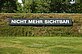 White lettering on a black background inside the wall of the sculpture park with the inscription "Nicht mehr sichtbar" [no longer visible]. On the other side of the wall on the grounds of the Schwarzl leisure center is the counterpart with the inscription "Noch nicht sichtbar" [not yet visible].