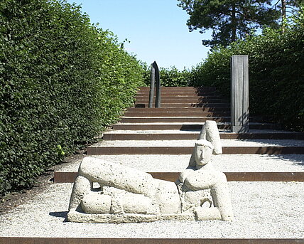 Die Steinskulptur "Die große Ruhende" am Fuße der Himmelstreppe im Fasanengarten. 