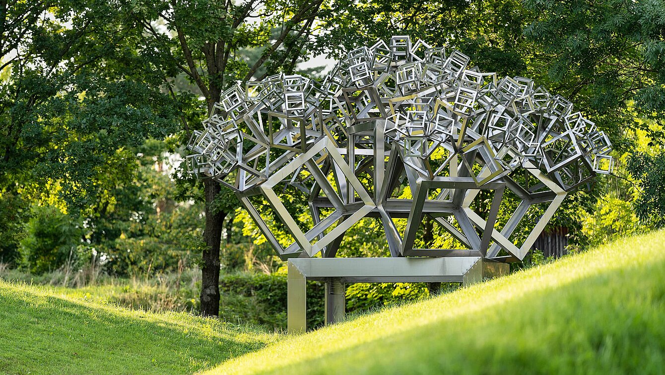 The sculpture is an ingenious construction in which five further cubes grow from one cube. The seemingly technical title refers to the year of creation, the shape (hexahedron) and the design. The cubes are reduced in size by a factor of 0.44902, and the proportions follow the golden ratio, creating a particularly harmonious effect. 