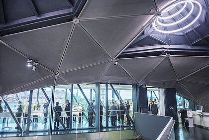 Guests at a reception in the Needle can be seen through the glasses facing the entrance to the Needle and Space01.