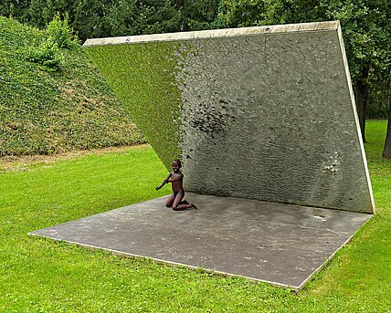 In the alpine garden of the sculpture park there is a diagonally rising concrete wall. It has small pieces of mirror on the underside. The environment is refracted by the sunlight in the shards. 