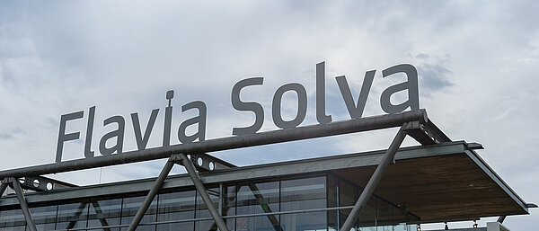 Die Fassade des Ausgrabungspavillons in Flavia Solva mit dem Schriftzug "Flavia Solva" am Dach.