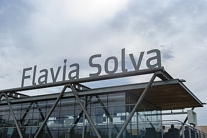 Die Fassade des Ausgrabungspavillons in Flavia Solva mit dem Schriftzug "Flavia Solva" am Dach.