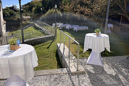 Bar tables and seating are set up in the fragrance garden in the Heimatsaal in the Folk Life Museum.