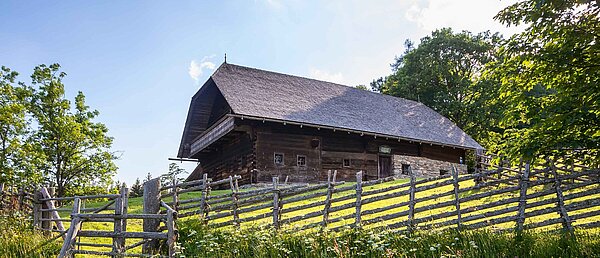 Das Geburtshaus Peter Roseggers mit Bänderzaun im Vordergrund