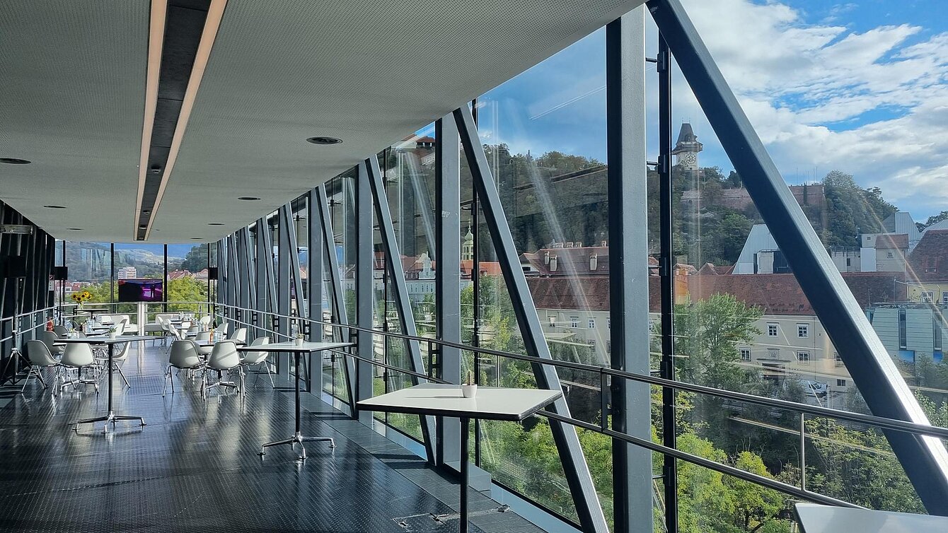 In the Needle in the Kunsthaus Graz, standing tables are in the foreground. Small coffee house seating groups are set up in the background.