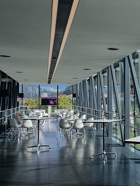 In the Needle in the Kunsthaus Graz, standing tables are in the foreground. Small coffee house seating groups are set up in the background.