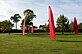 Sails mounted on tilting poles rise up at the rear of the pheasant garden. They move in the wind. 