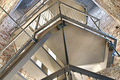 
Photo of a concrete and metal staircase in a narrow tower