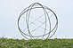 A sphere made of six metal circles rises from an earth pyramid above the water lily pond. It is one four-millionth of the earth. 