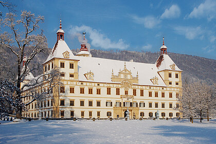 Der Vorplatz und das Schloss Eggenberg sind winterlich verschneit.