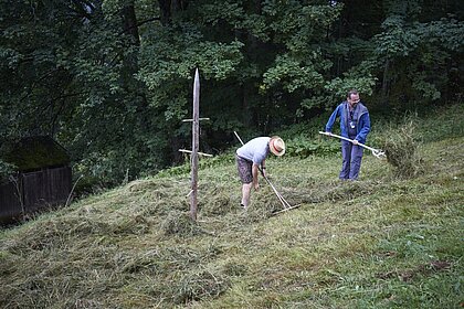Zwei Männer bei der Heuarbeit