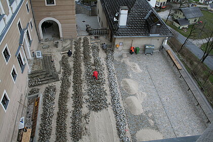 
Aerial view of the castle courtyard where paving stones are being laid.