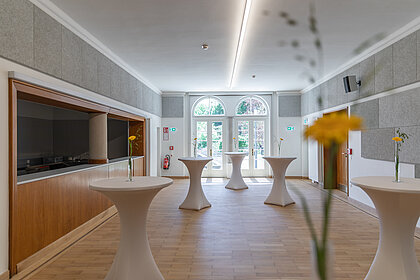 View of the foyer in the Heimatsaal with bar tables.