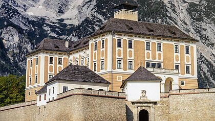 Buchcover des Katalogs Schloss Trautenfels. Auf dem Cover ist ein Foto von Schloss Trautenfels bei Sonne vor dem Berg Grimming abgedruckt