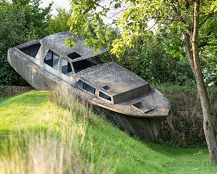 Michael Schusters Betonboot auf einem begrünten Erdwall im Österreichischen Skulpturenpark