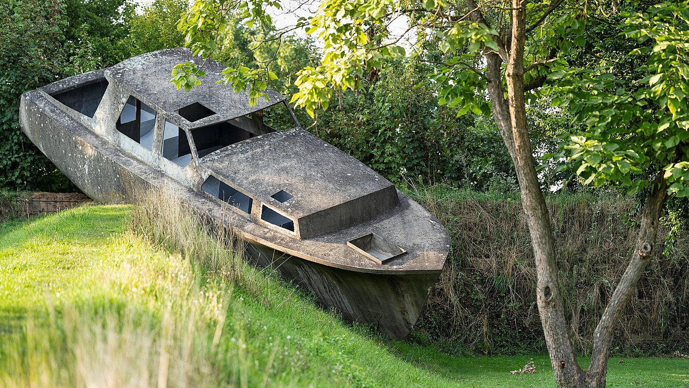 Michael Schusters Betonboot auf einem begrünten Erdwall im Österreichischen Skulpturenpark