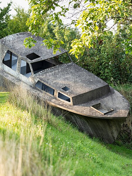 Michael Schusters Betonboot auf einem begrünten Erdwall im Österreichischen Skulpturenpark