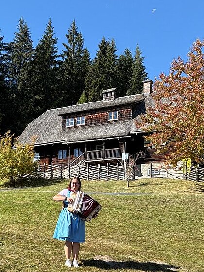 Eine junge Harmonikaspielerin am Wiesenhang
